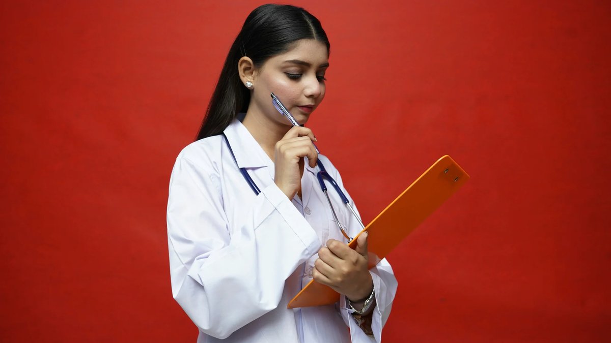Étudiante en médecine avec blouse blanche consultant ses notes de recherche
